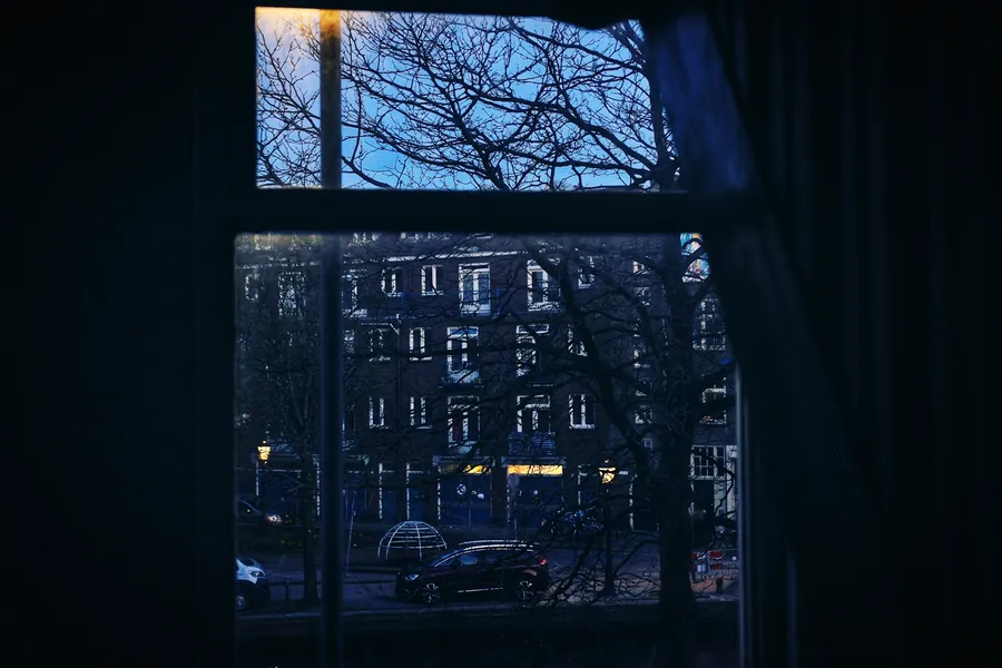 Ventana de una habitación a oscuras de madrugada